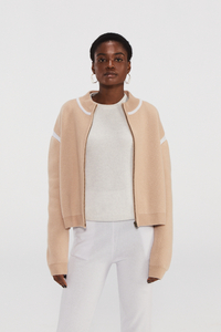 ベージュカシミアニットボンバージャケットと白いトリム